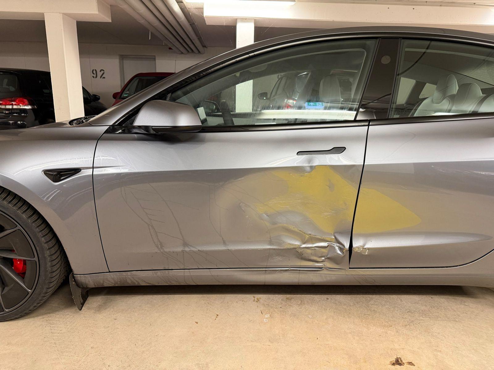 Tesla Model 3 mit Seitenschaden in einer Tiefgarage